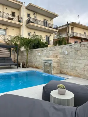 a swimming pool in front of a building at Amare suite 2 in Perivólia