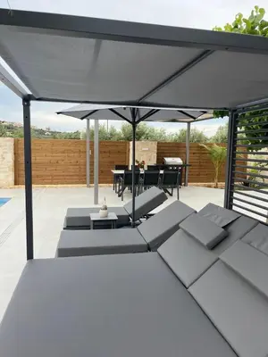 a white patio with a table and an umbrella at Amare suite 2 in Perivólia