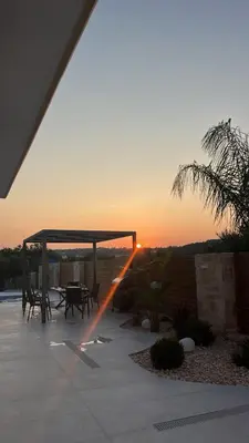 a sunset over a patio with a table and chairs at Amare suite 2 in Perivólia