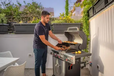 a man is cooking food on a grill at The Nest in Chania Town