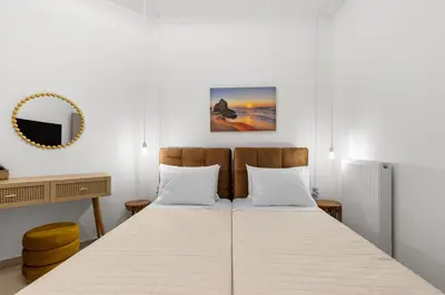 a bedroom with two beds and a mirror at Palea Luxury Living in Galatás