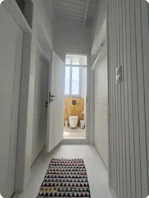 a hallway with a bathroom with a toilet and a rug at Filoi Rooftop Boutique House,5pax in Chania Town