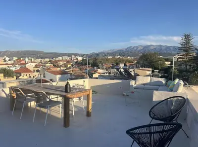 a patio with a table and chairs on a roof at Filoi Rooftop Boutique House,5pax in Chania Town