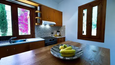 a kitchen with a bowl of bananas on a wooden table at SeawoodBreeze - Sea view and Quiet Escape in Tavronitis