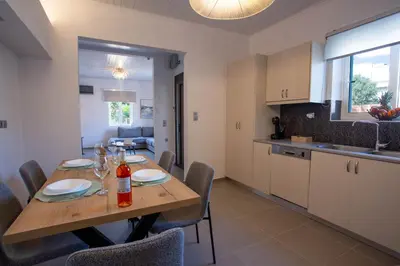 a kitchen and dining room with a wooden table and chairs at Be Crete - Villa Del Sol in Chania Town