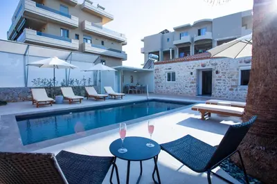 a swimming pool with chairs and a table with wine glasses at Be Crete - Villa Del Sol in Chania Town
