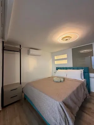 a bedroom with a large bed with a blue headboard at Eteà Sea Penthouse-In the heart of chania in Chania Town