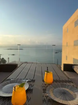 two glasses of orange juice sitting on a table at Eteà Sea Penthouse-In the heart of chania in Chania Town