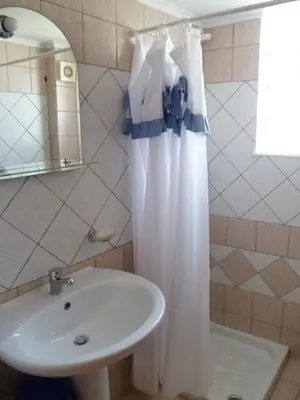 a bathroom with a sink and a shower curtain at Anniko in Stalos
