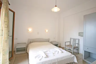 a bedroom with a bed and a mirror and a chair at Anniko in Stalos
