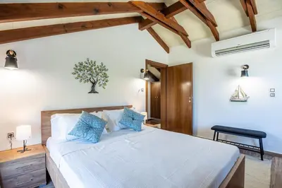 a bedroom with a large white bed with blue pillows at Villa Rose in Chania Town