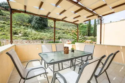 a patio with a glass table and chairs at Villa Rose in Chania Town