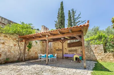 a wooden pergola with a table and chairs at Villa Rose in Chania Town