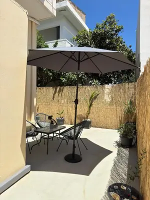 a table and chairs under an umbrella on a patio at Unique Apartment 3 in Chania Town