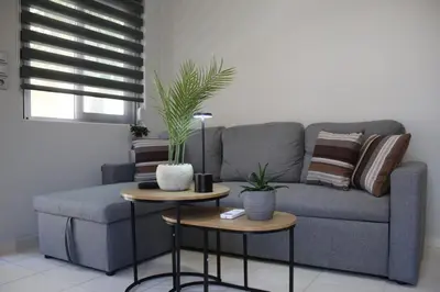 a living room with a couch and two tables with plants at Unique Apartment 2 in Chania Town