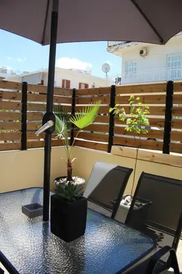 a table with an umbrella on a balcony at Unique Apartment 2 in Chania Town