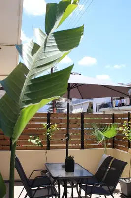 a table and chairs on a balcony with a large leafy plant at Unique Apartment 2 in Chania Town