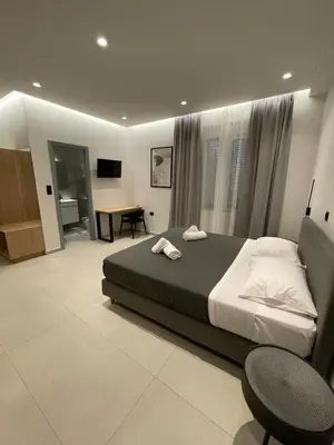 a bedroom with a bed and a desk in it at Pnoé studio, Chania Center in Chania Town