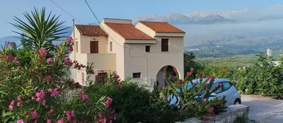 a house with a car parked in front of it at Kaina Villa in Vamos