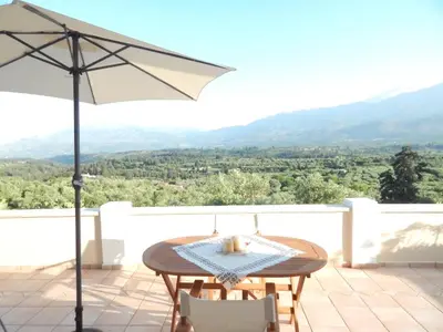 a table and chairs on a patio with an umbrella at Kaina Villa in Vamos