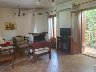 a living room with chairs and a fireplace and a tv at Villa Eudokia Terrace Views Pool in Douliana