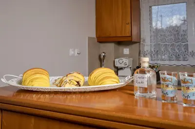 a plate of bananas on a counter with a bottle of alcohol at Sellianos Apartment In Kalyves -BY APOKORONAS VILLAS in Kalyves