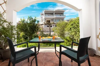 a patio with a table and chairs and a building at Sellianos Apartment In Kalyves -BY APOKORONAS VILLAS in Kalyves