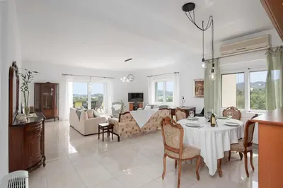 a living room with a table and a couch at Olive Ηouse, Quiet, Cozy, mountain view, family in Milonianá