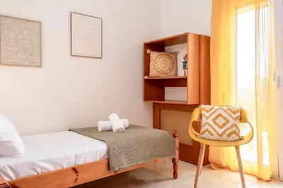 a small bedroom with a bed and a chair at Olive Ηouse, Quiet, Cozy, mountain view, family in Milonianá