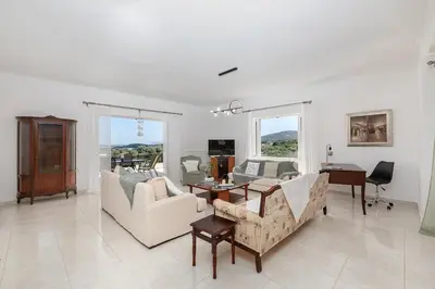 a living room with a couch and a table at Olive Ηouse, Quiet, Cozy, mountain view, family in Milonianá