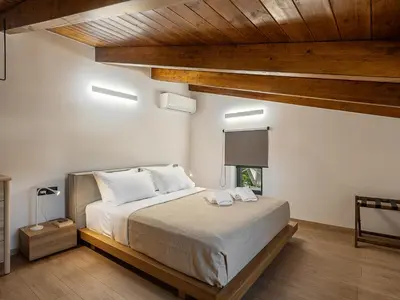 a bedroom with a large bed with wooden ceilings at Petra Retreat Residence in Daratso