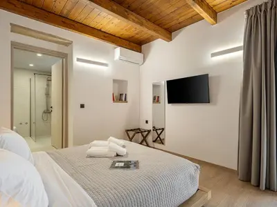 a bedroom with a bed and a tv on the wall at Petra Retreat Residence in Daratso