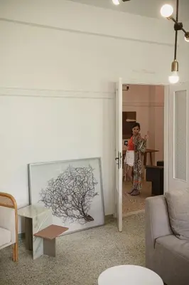 a person standing in a living room with a drawing on the wall at Eva's Apartment in Chania Town