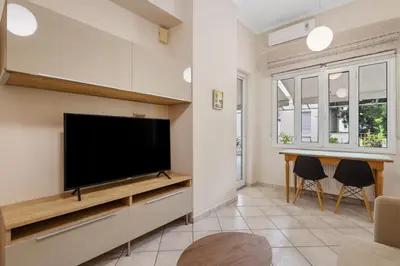 a living room with a flat screen tv on a wall at Architects Oasis in Chania Town