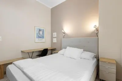 a bedroom with a white bed and a desk at Architects Oasis in Chania Town