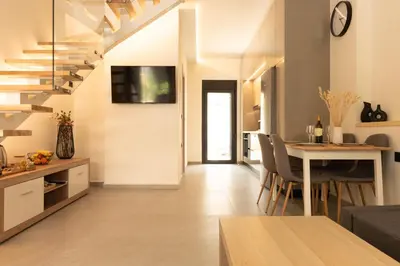 a kitchen and living room with a table and chairs at Ikaros City Loft in Chania Town