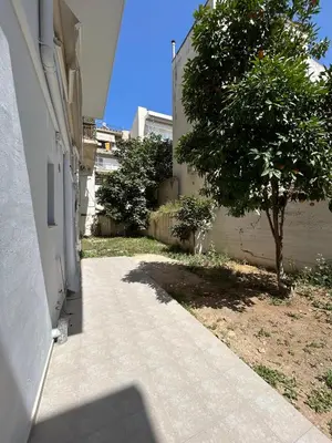 a sidewalk next to a building with a tree at Ikaros City Loft in Chania Town