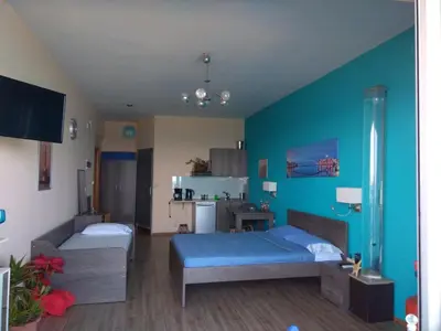 a room with two beds and a kitchen in it at Blue Studios in Chania Town