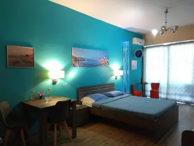 a bedroom with a blue wall with a bed and a table at Blue Studios in Chania Town