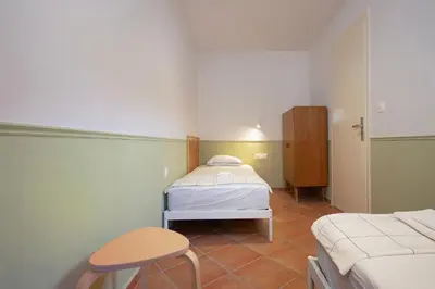 a small room with a bed and a stool at Artemis House in Chania Town