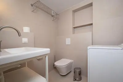 a white bathroom with a toilet and a sink at Artemis House in Chania Town