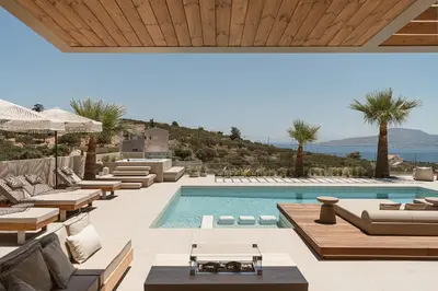 an outdoor swimming pool with lounge chairs and a villa at Villa Niolos I in Marathi