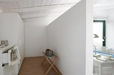 a kitchen with white walls and a table and a window at Villa Niolos I in Marathi