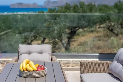 a basket of bananas and apples on a table on a patio at Liastera Luxury Apartments in Áyios Fótios