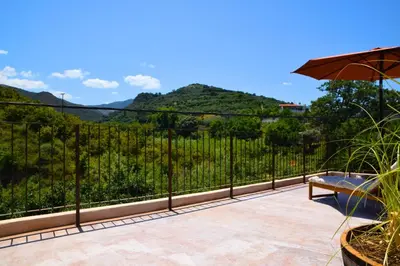 a balcony with an umbrella and a view of a vineyard at Mozaik House