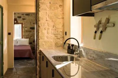 a kitchen with a sink and a stone wall at Mozaik House