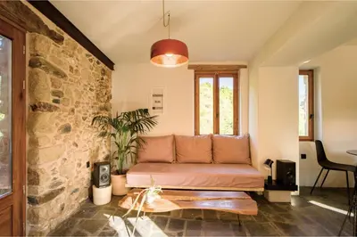 a couch in a room with a stone wall at Mozaik House