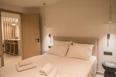 a bedroom with a bed with white sheets and pillows at Kalmar mindful living in Palaiochóra