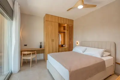 a bedroom with a bed and a table and a desk at Villa Tierra in Kissamos
