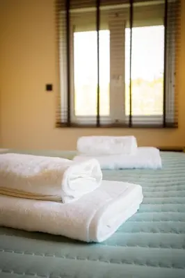 two white towels sitting on top of a bed at Mantarini House in Chania Town